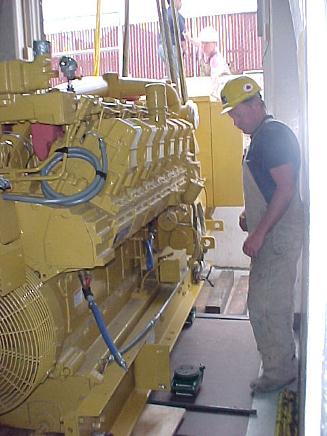 Caterpillar, 3512 diesel engine generator rigged through a basement doorway- close up with skid into the foyer.
